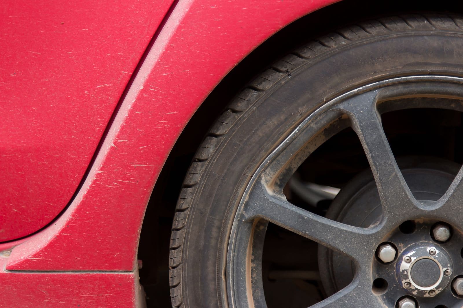 Close-up of a low-tread tyre on a red car