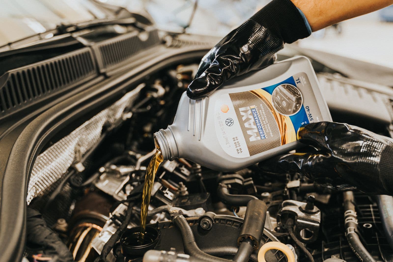Fresh engine oil being poured into an engine during an oil change