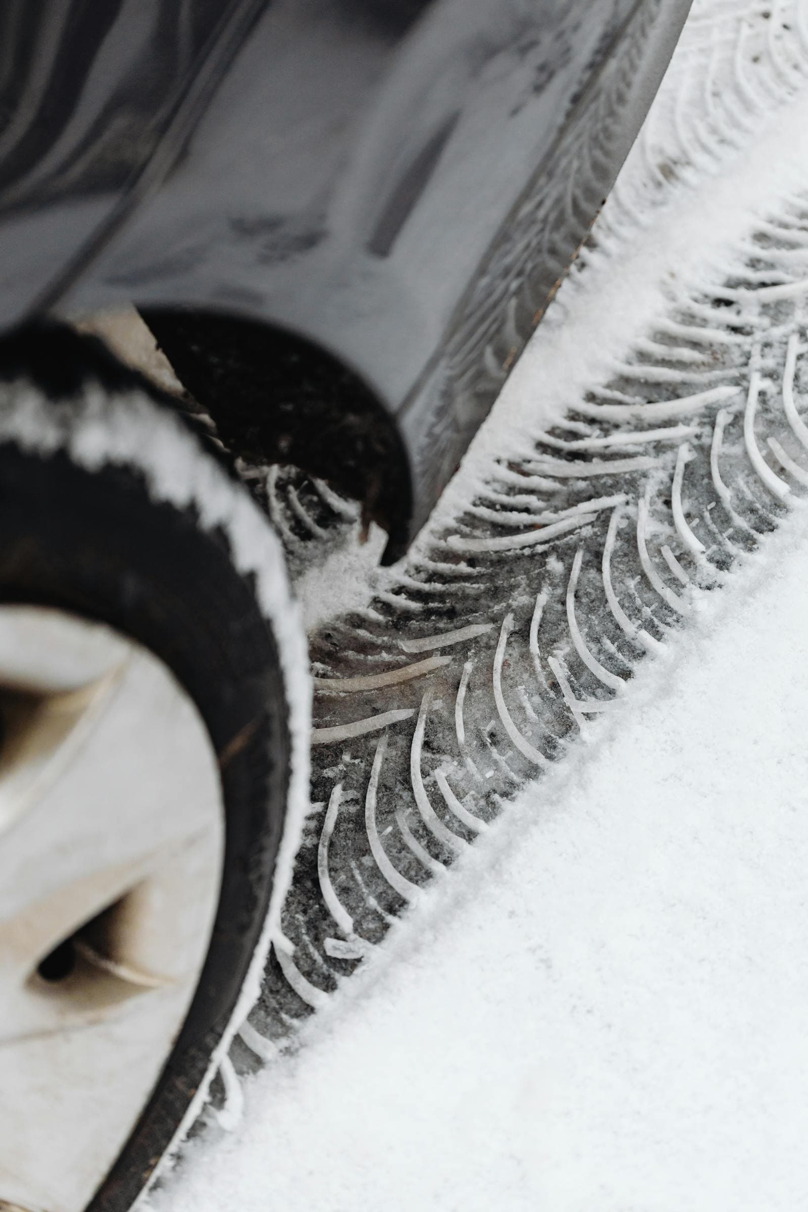 Close-up of a car tyre with snow packed into the tread